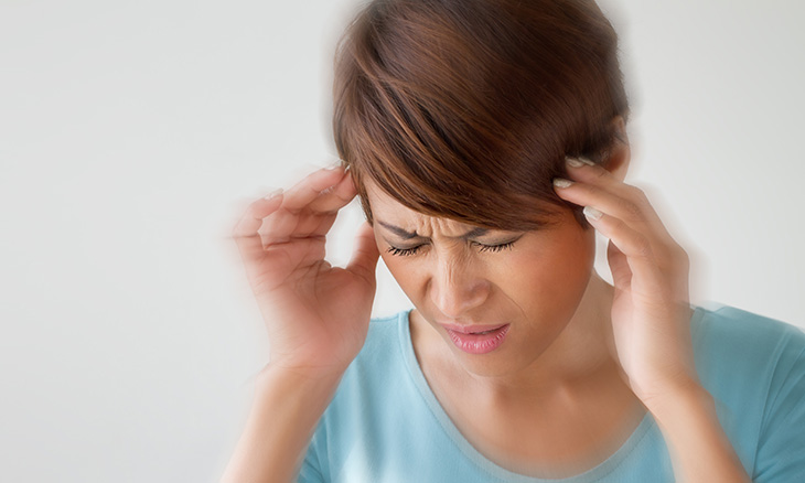A woman with a headache holding her head